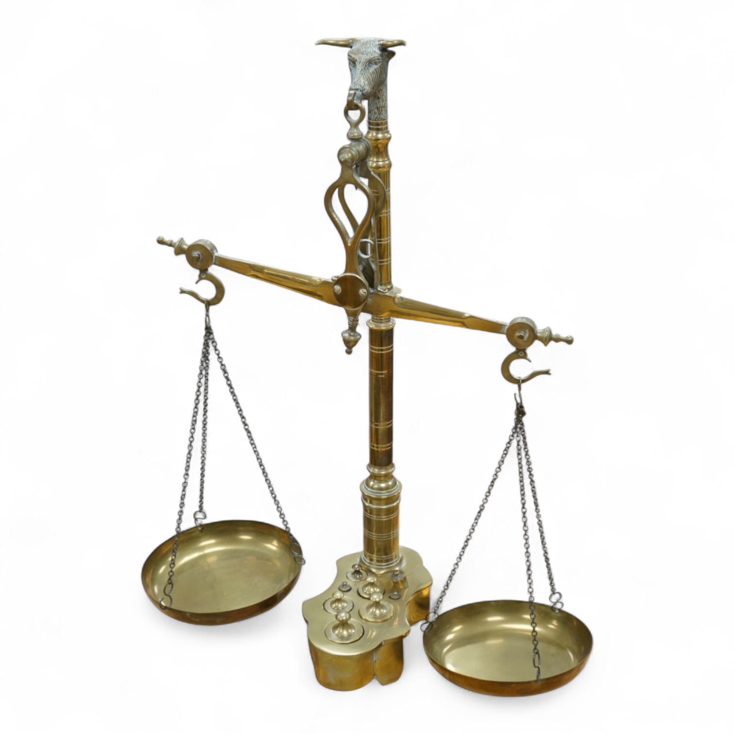 A pair of brass beam scales with decorative bull's head finial and weights, 56cm high